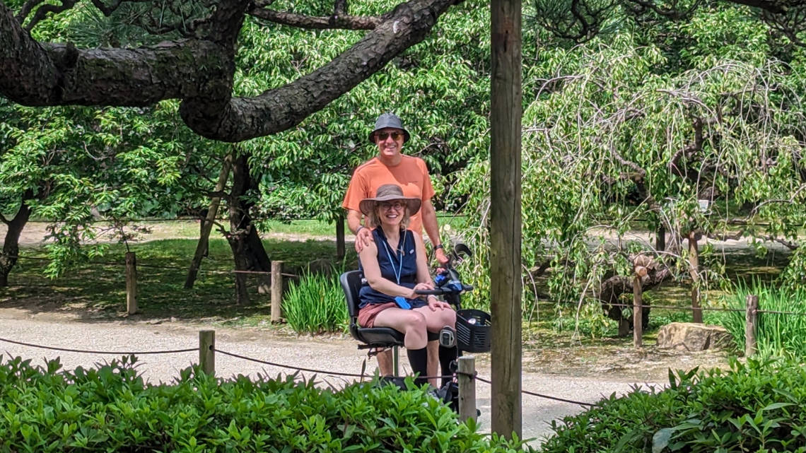 A couple sitting in a mobility scooter smiling